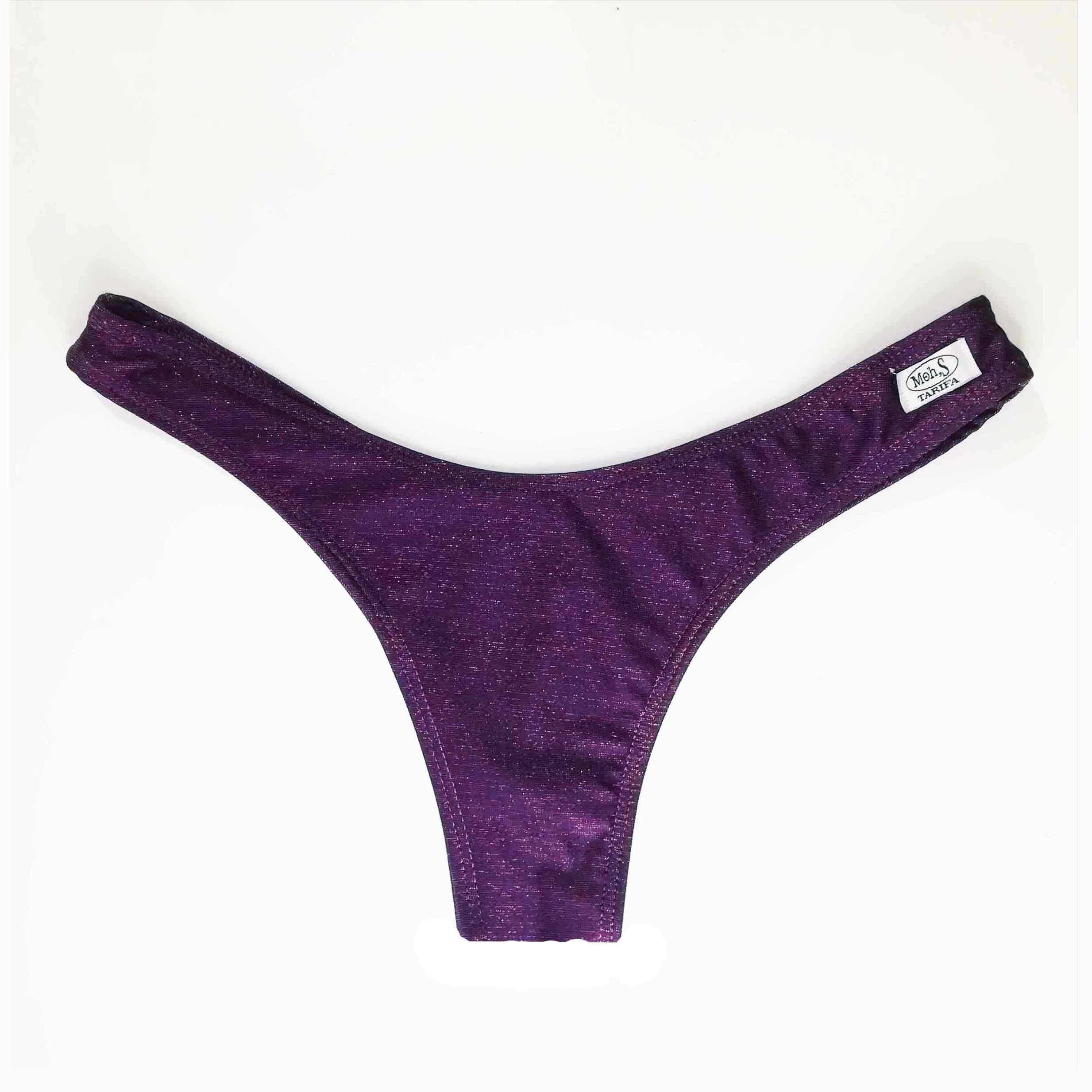 Detalle de braga de bikini brasileña con corte en V y talle alto, confeccionada en tejido lurex color berenjena con brillo sutil.