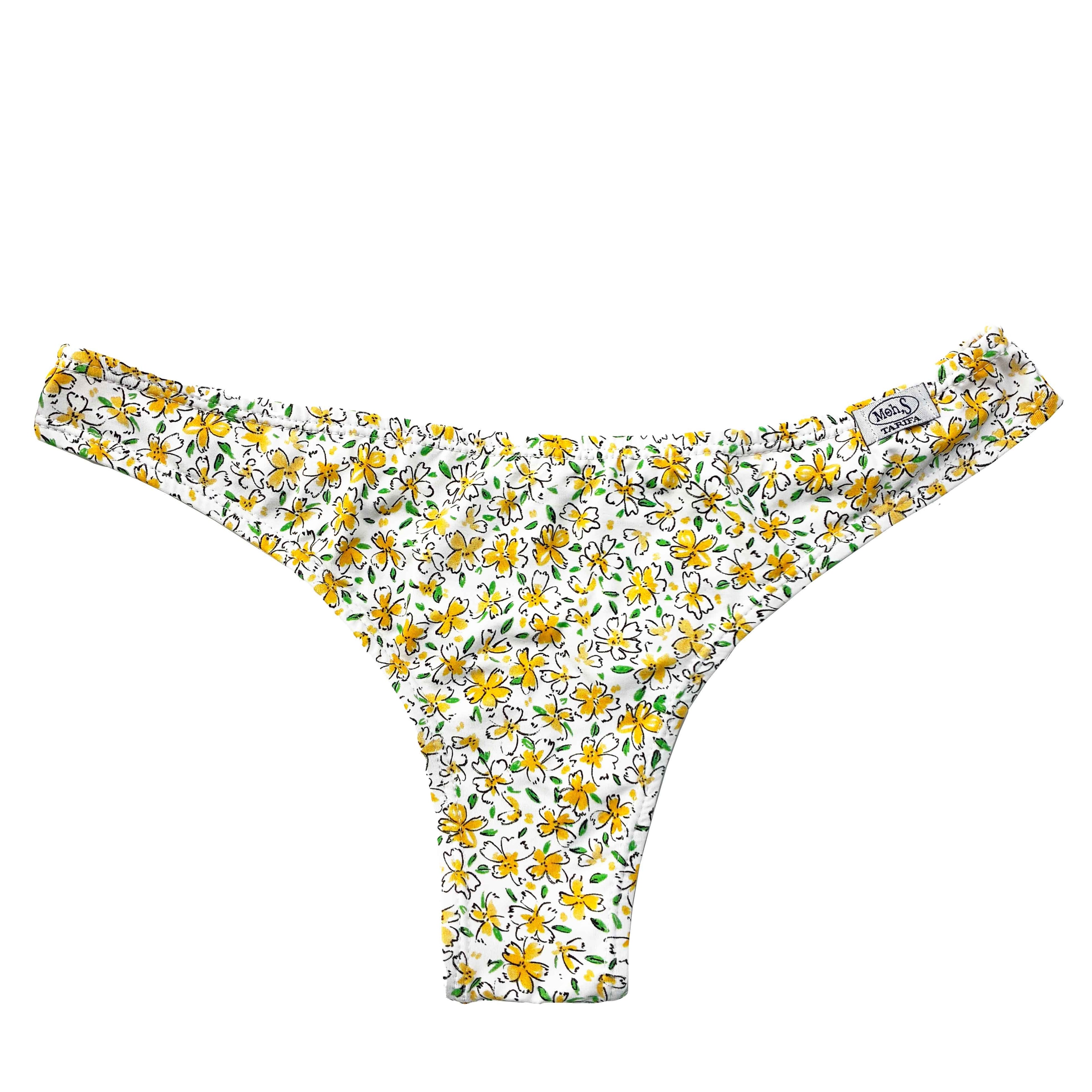 Braguita de bikini de corte brasileño con estampado de flores amarillas sobre fondo blanco, diseño artesanal.
