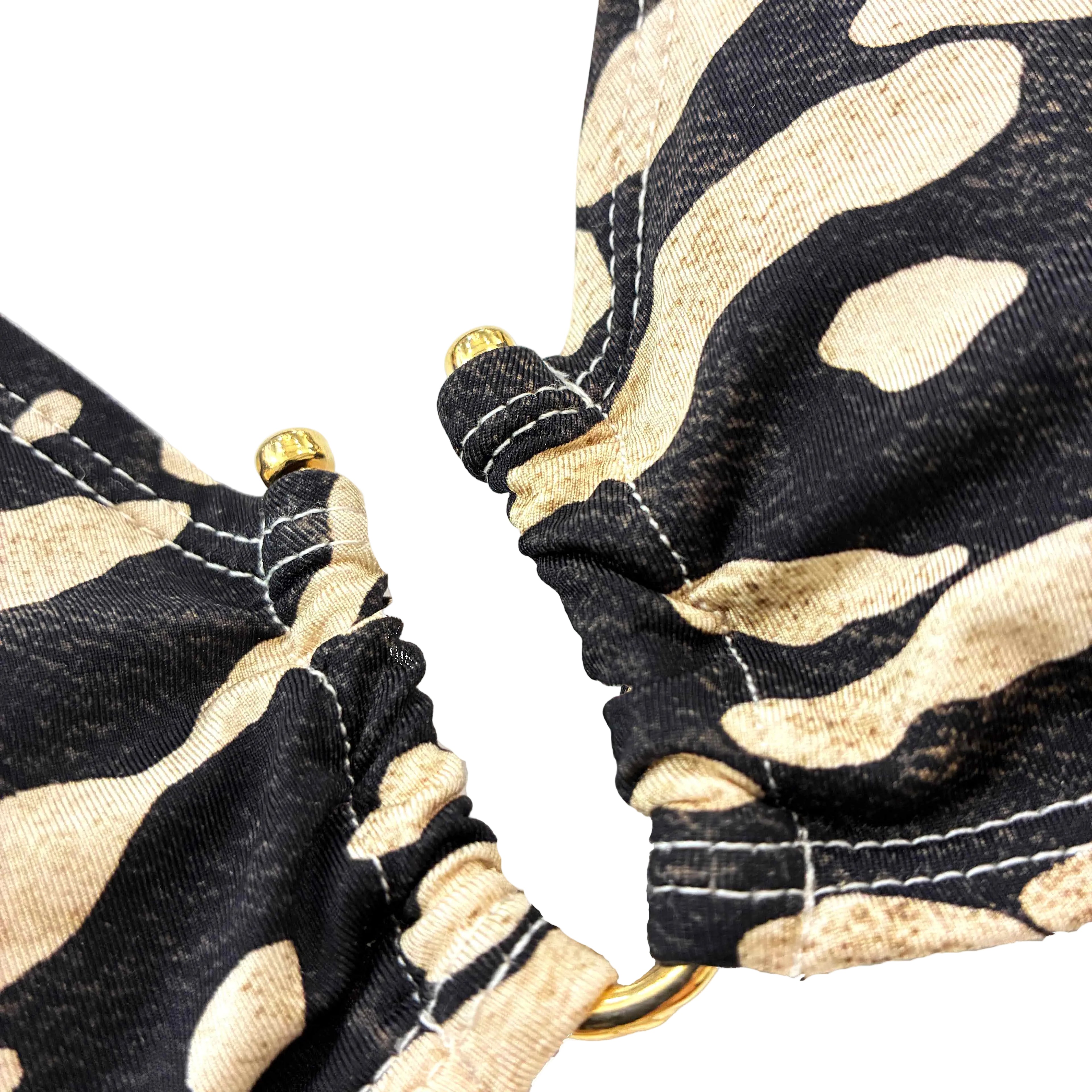 Detalle dorado de bikini de estampado animal de cebra
