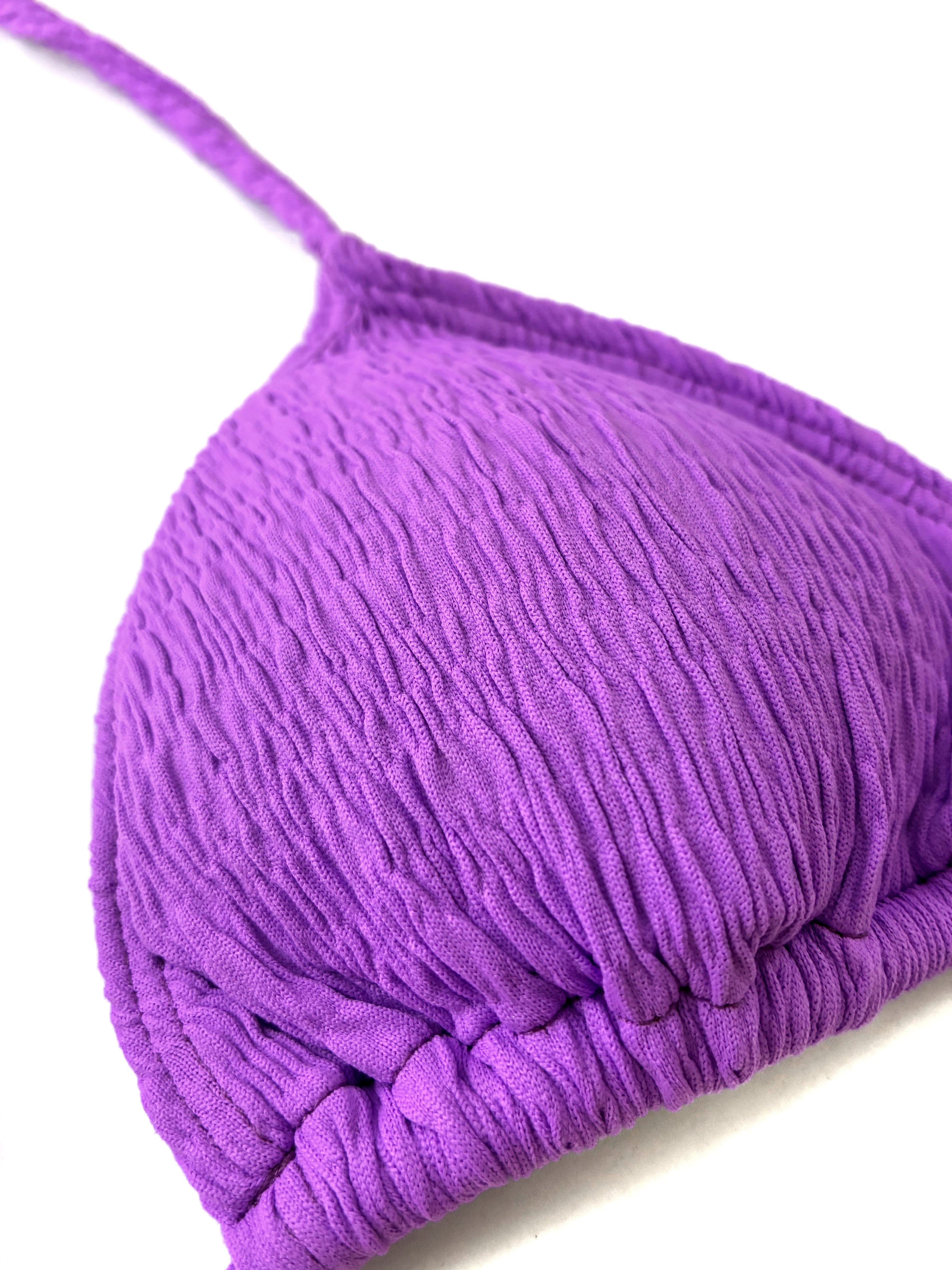Detalle del top de bikini tipo cortina en color lila con tejido de textura rugosa y tirantes trenzados, confección artesanal.