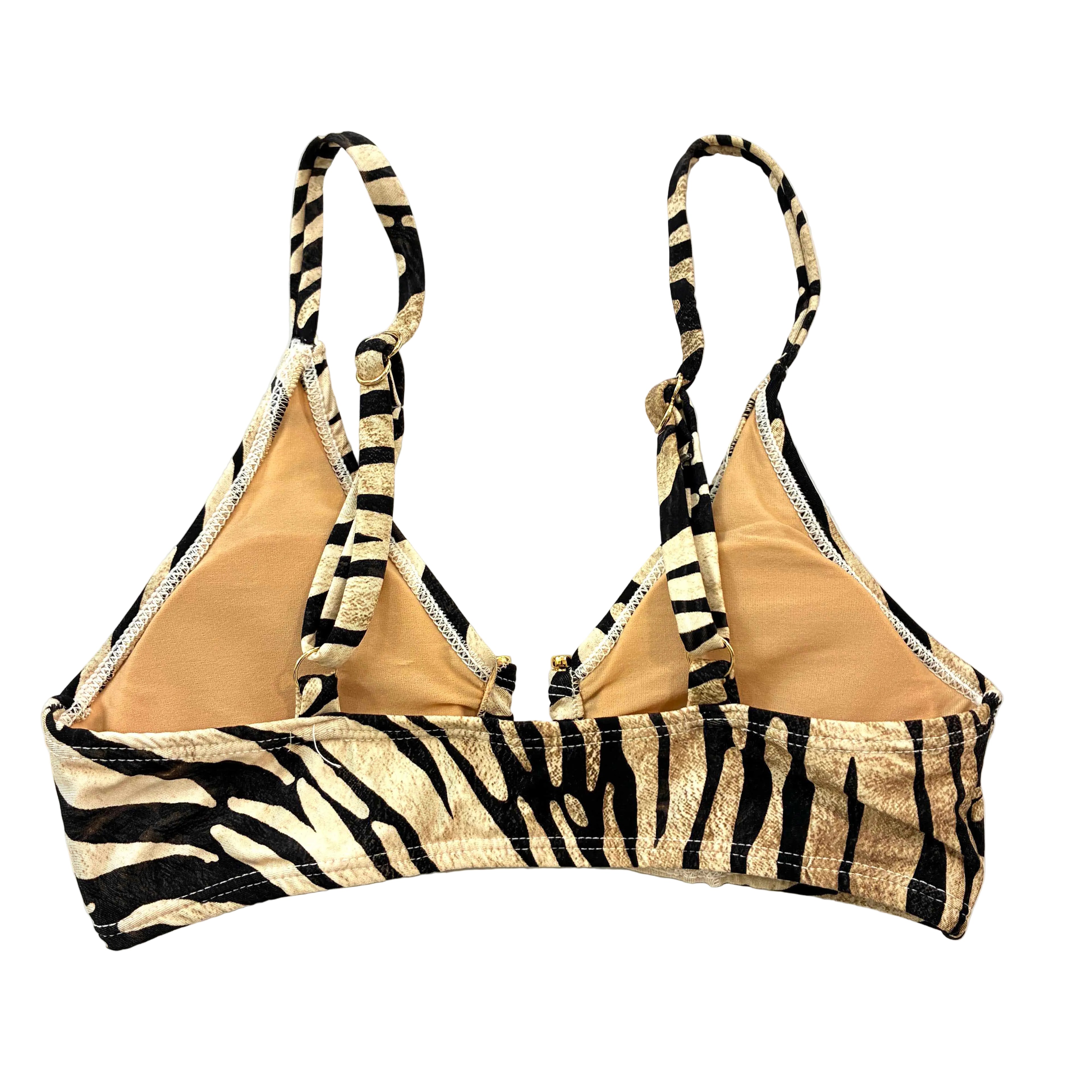 Top de bikini tipo bralette con estampado de cebra en color crema y negro, con detalle de adorno metálico dorado en el escote y tirantes regulables.