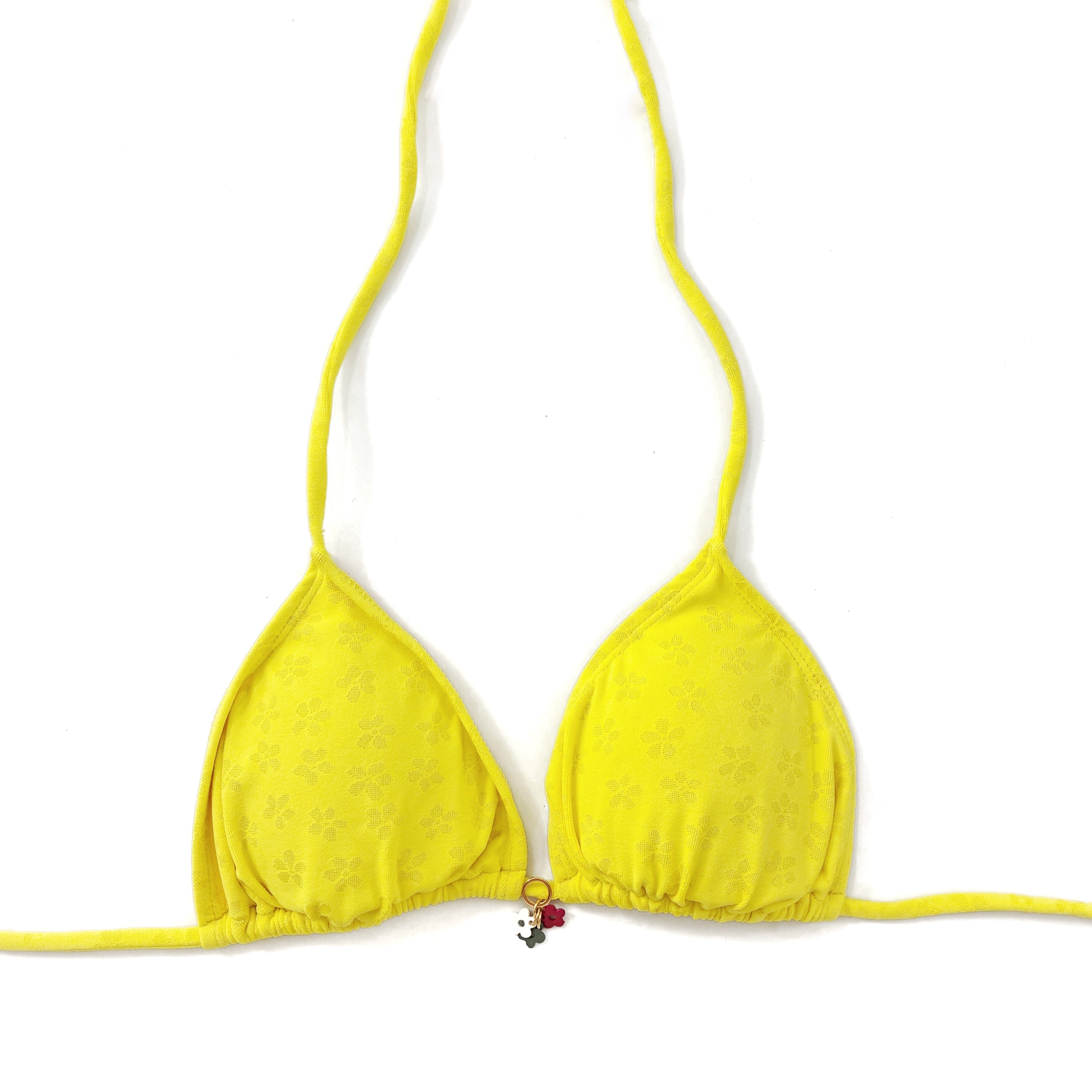 Top de bikini tipo cortina en color amarillo intenso con detalle de abalorio central, modelo artesanal en la playa.