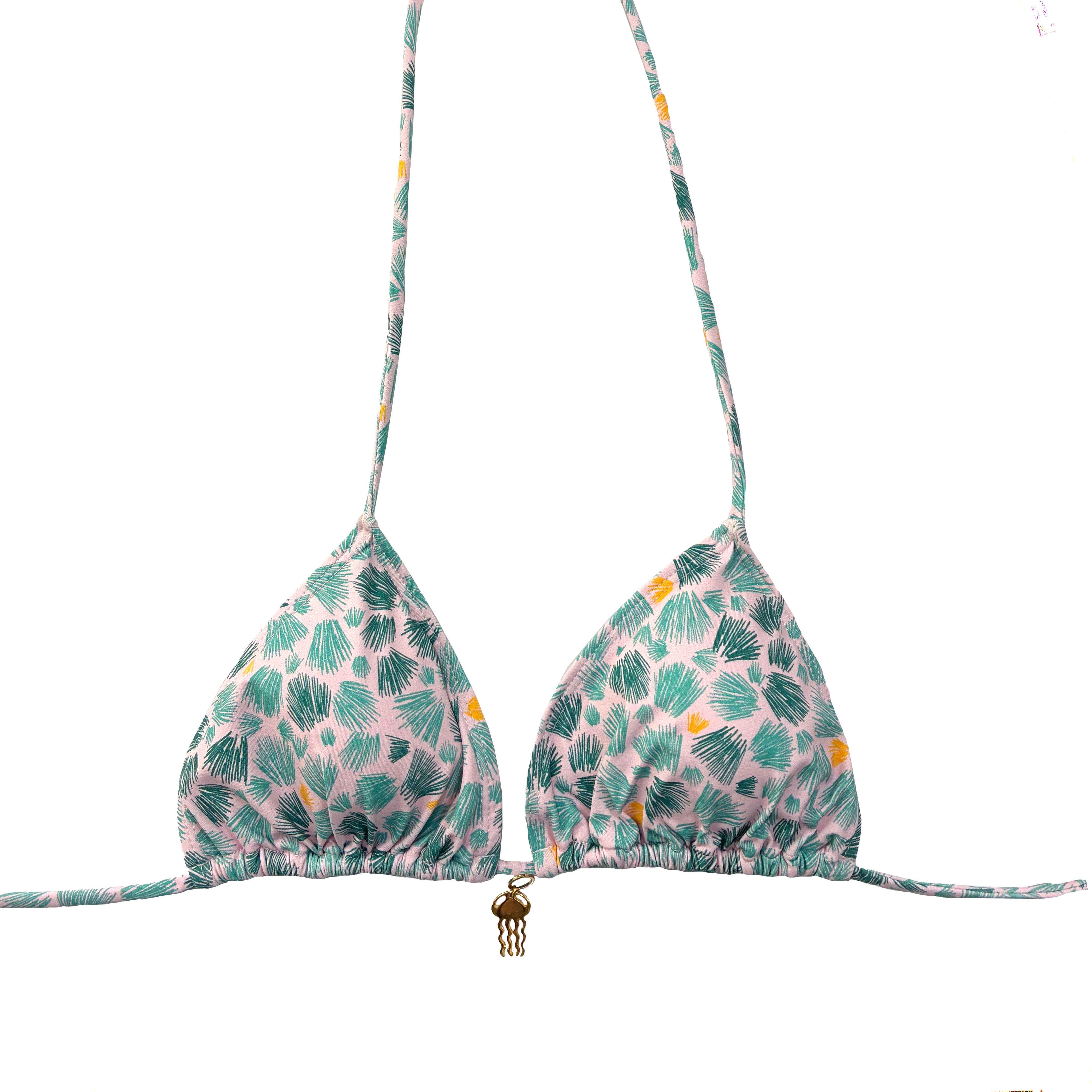 Top de bikini de triángulo con estampado de palmeras verdes y detalle de colgante dorado en el centro.