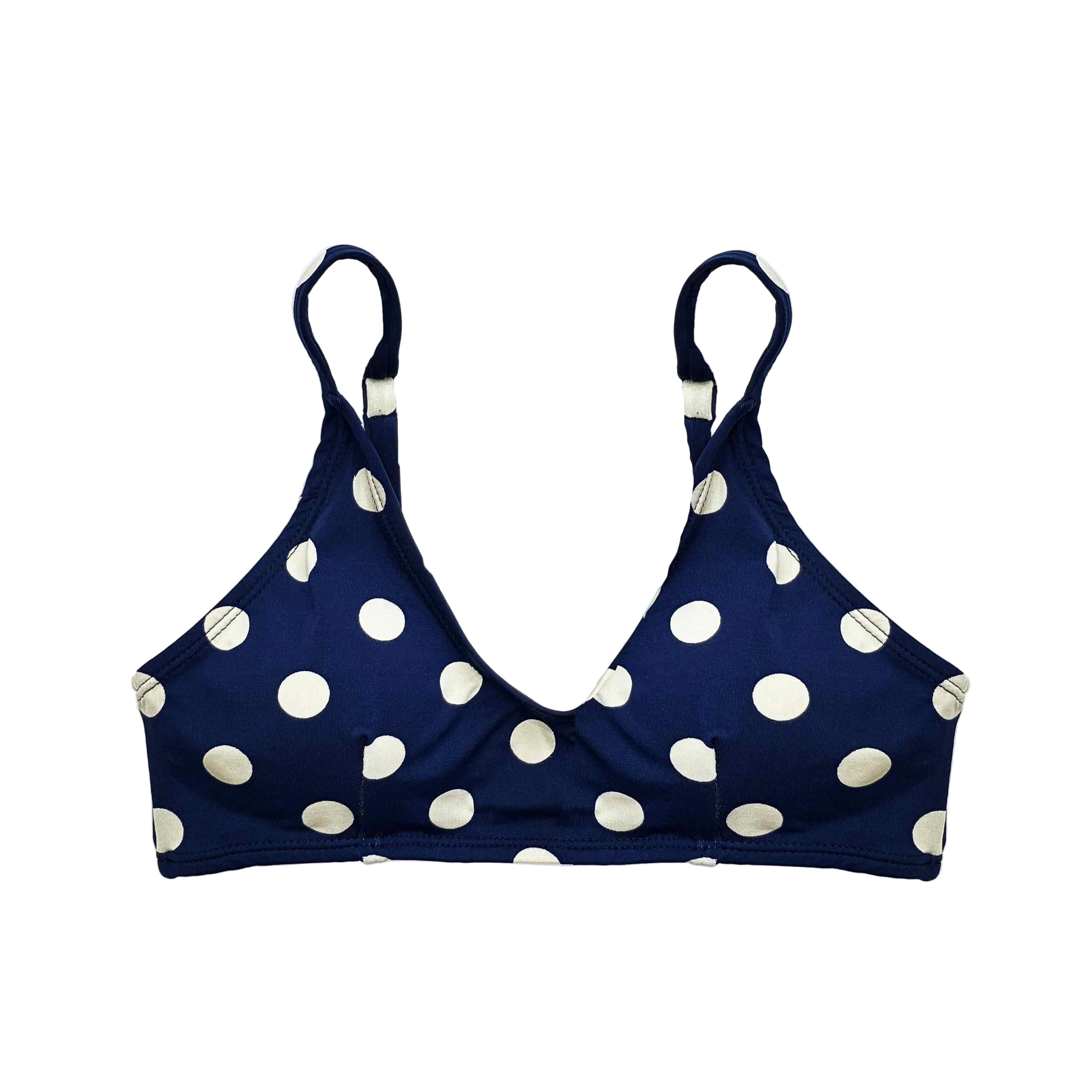 Top de bikini tipo bralette con estampado de lunares blancos sobre fondo azul marino y tirantes regulables.