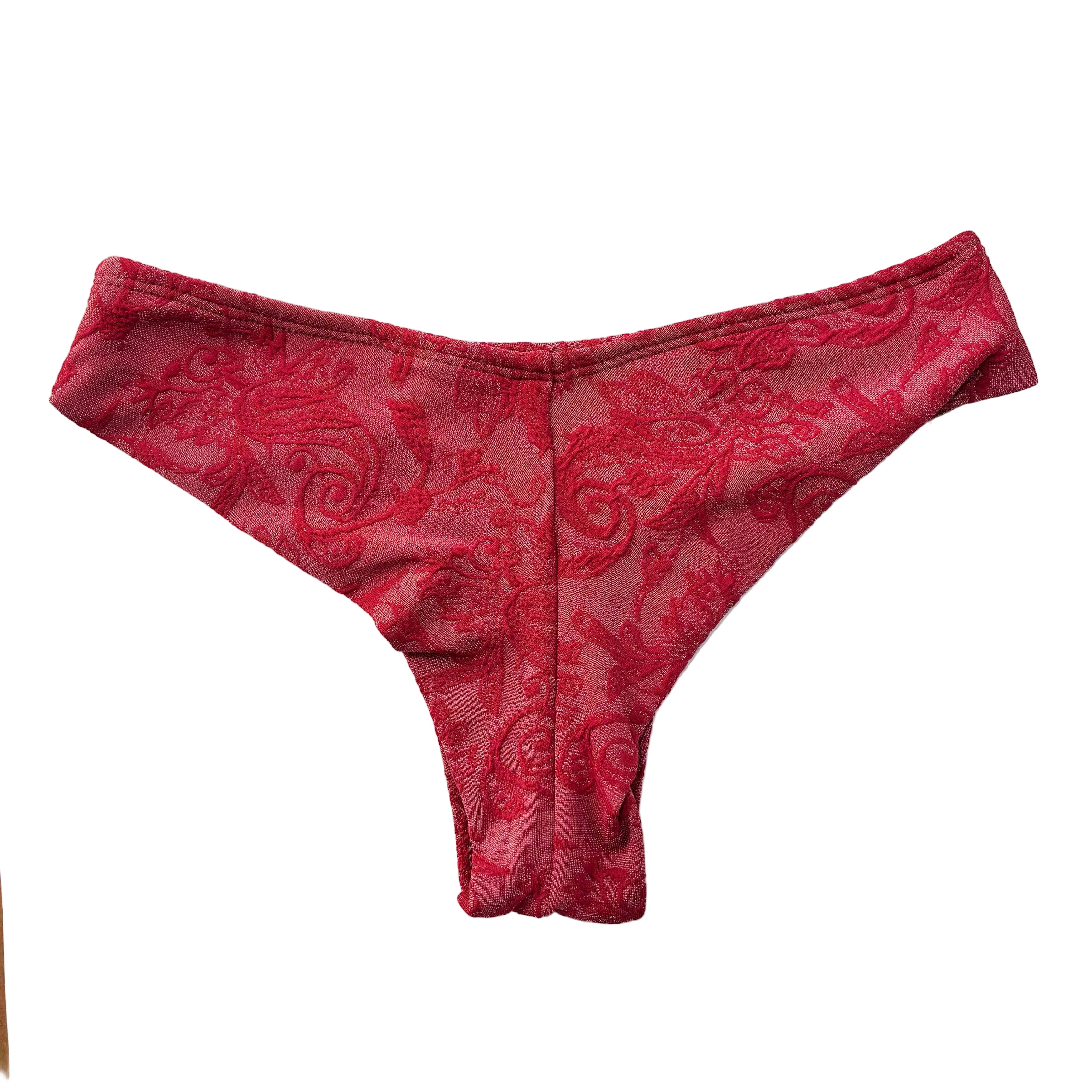 Vista trasera de braga semitanga artesanal de terciopelo paisley rojo, mostrando el patrón completo del tejido y la forma de la cobertura trasera, sobre fondo blanco. Marca Moh,S Tarifa.