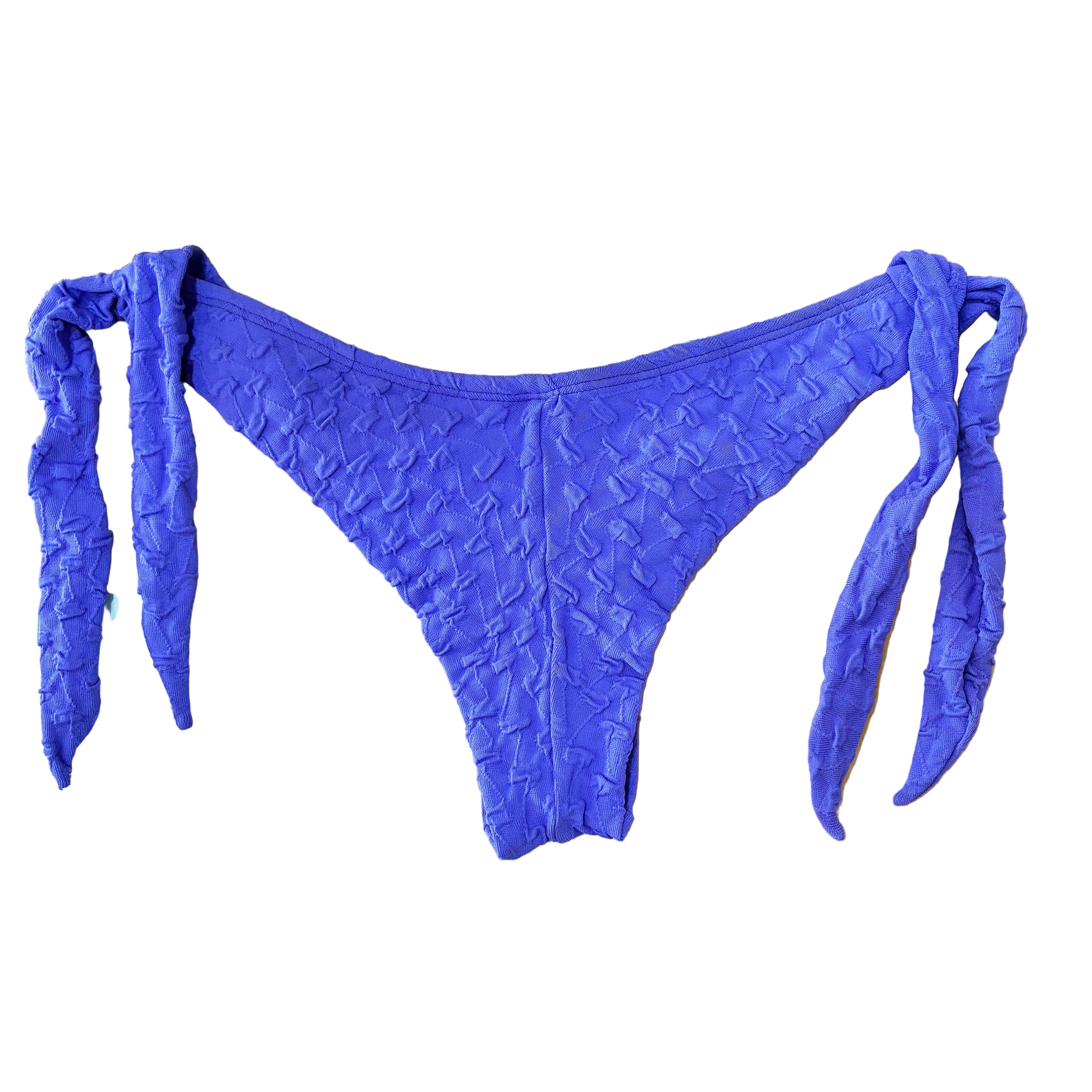 Trasera de braga de bikini estilo semitanga con lazos laterales en tejido lila texturado, sobre fondo blanco.