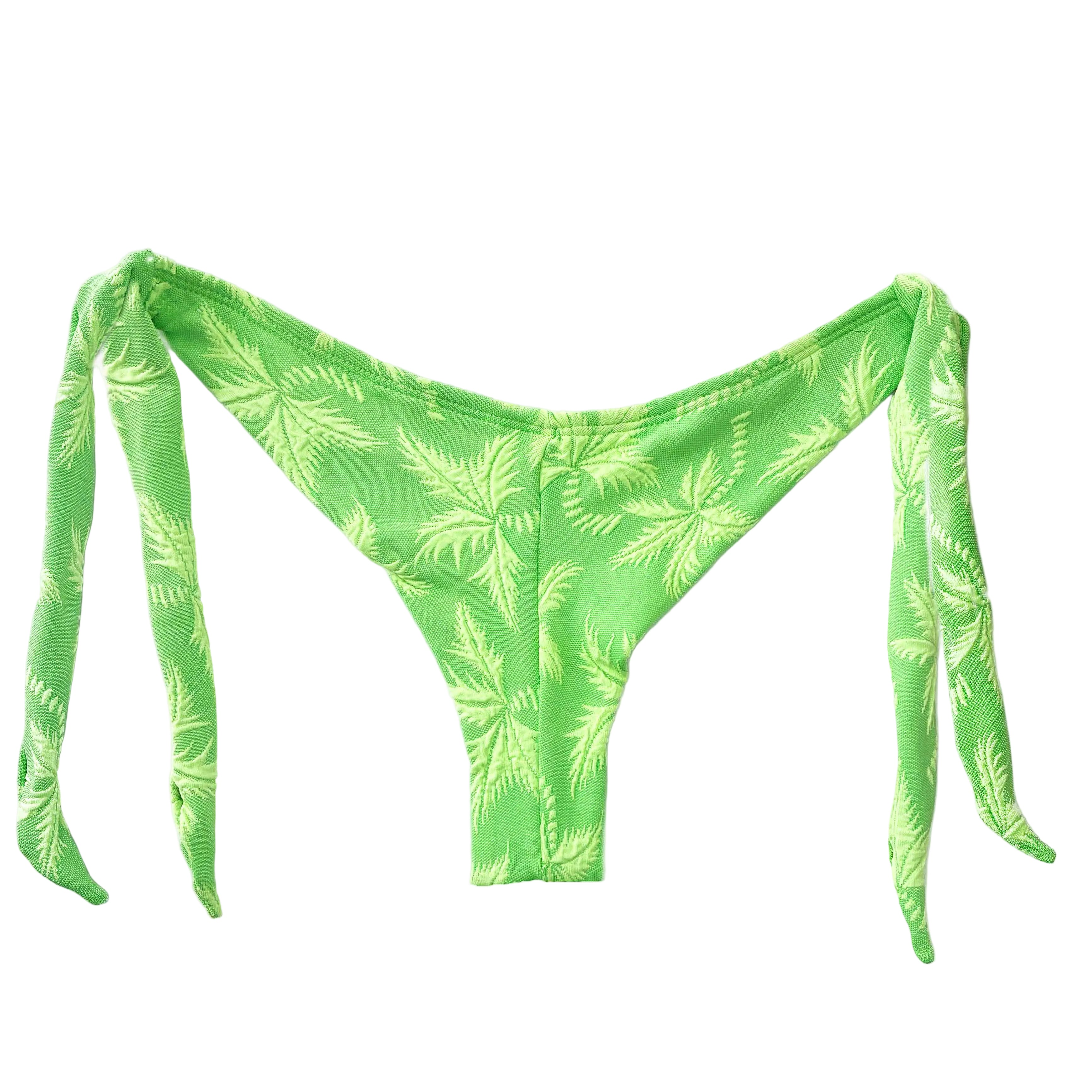 Detalle de la parte trasera de braga de bikini brasileña con corte semitanga, diseño de lazos laterales y tejido de jacquard con relieve de palmeras en color verde lima.